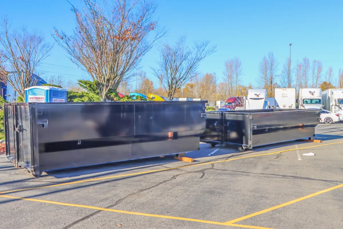 Professional dumpster rental service with roll-off container on residential driveway in Camden